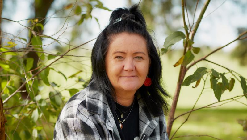 Portrait of smiling women posing in the shade of a young eucaluptas tree