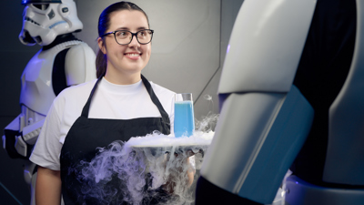 Woman in an apron serves blue milk on a smoking platter to a stormtrooper.