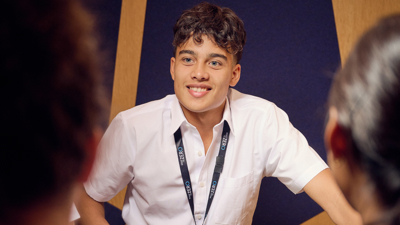 A student in the Road to Zero Learning Studio leaning on a touch table 