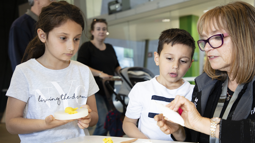 Volunteer assists visitors during school holiday activity at Melbourne Museum.