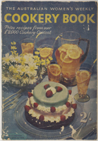 A cake, flowers and fruity drink on the cover of a faded magazine. 