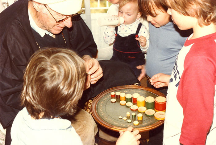 John Twycross surrounded by grandchildren, playing with the 'titchy' boxes purchased by his grandfather at the 1880 Melbourne International Exhibition.