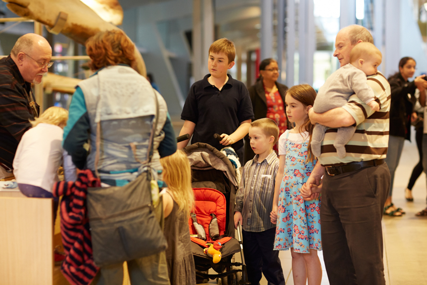 Crowd of people looking at a touch trolley at the museum
