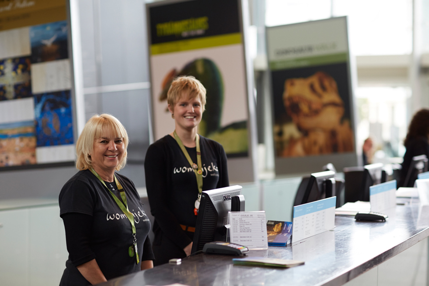 Two people working at the museum ticket desk