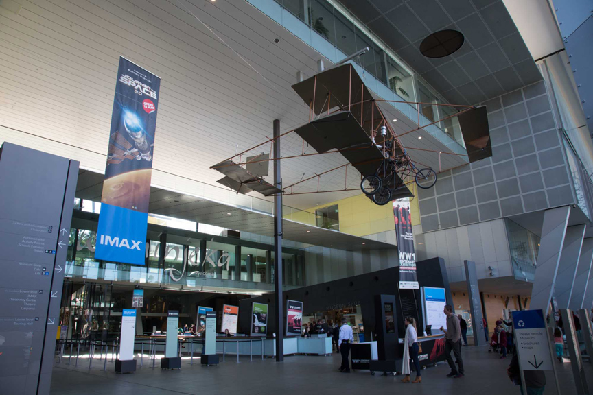 The foyer of Melbourne Museum where an old-fashioned aeroplane hangs from the ceiling