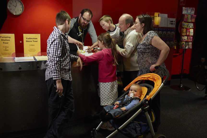 Man helping family at information desk museum