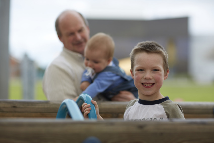 Boy with baby and man in background