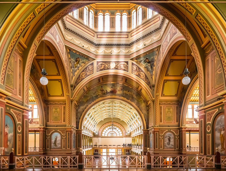Interior of the Royal Exhibition Building, with rays of sun shining down from the dome.