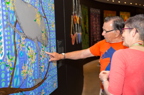 Artist Ted Laxton discussing a painting with a Museums Victoria staff member at the Pitcha Makin Fellas' Open Your Eyes exhibition launch