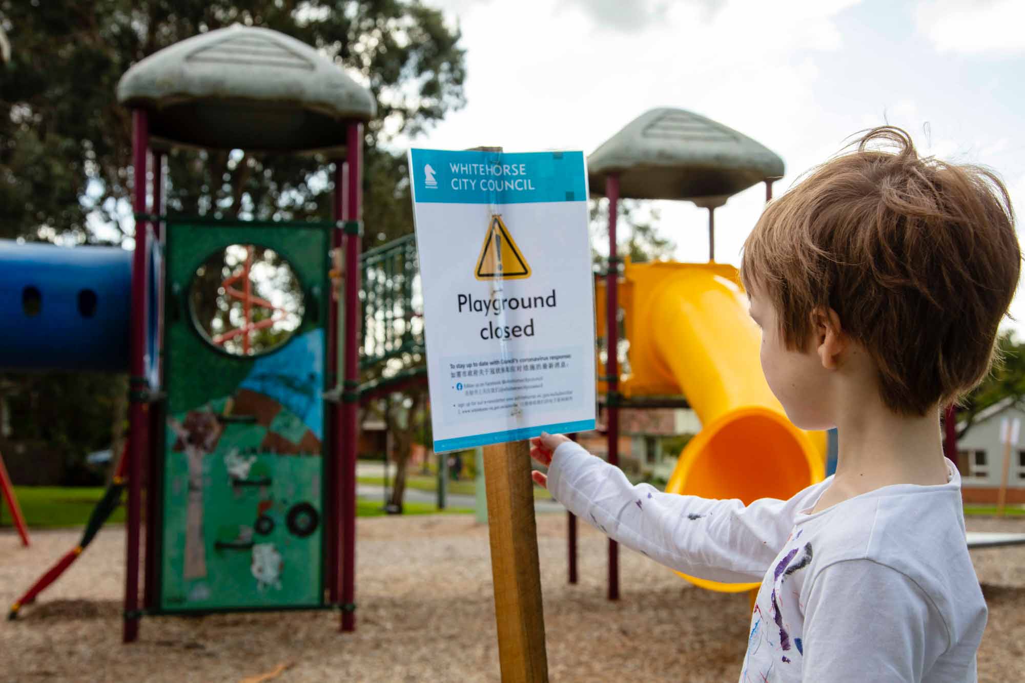 Child reading a sign in a playground