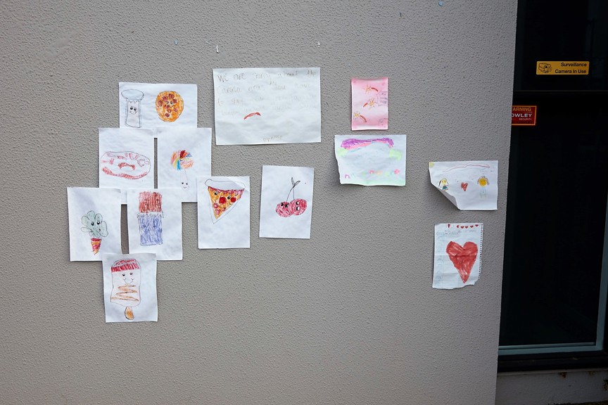 Children's drawings pinned to a wall