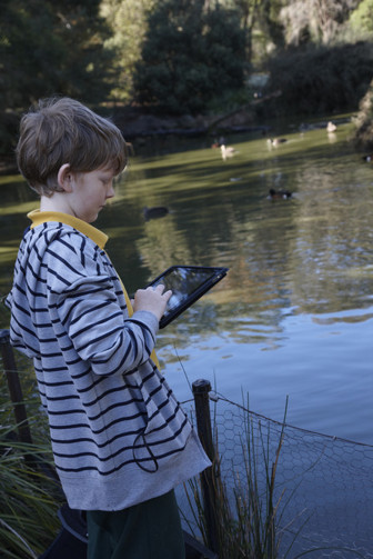 Child recording bird sightings on pad