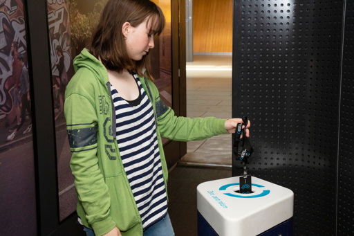 Teenager returning interactive pass at the Road To Zero experience space exit