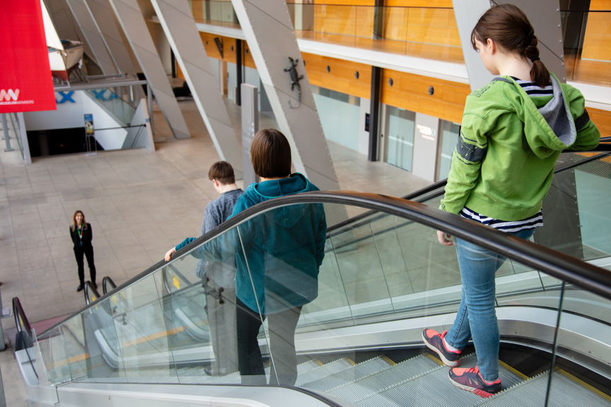Road to Zero presenter Elke Barczak waiting at the bottom of the escalators to greet teenagers and accompanying adult coming to the Road to Zero Learning Studios, located on the lower ground at Melbourne Museum