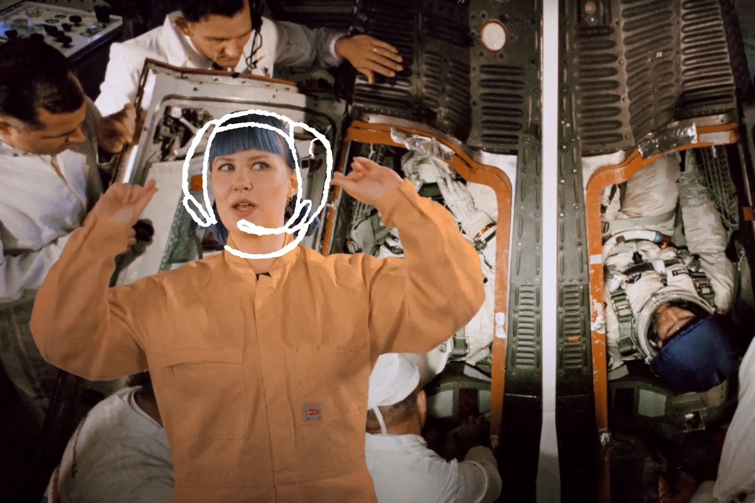 Woman wearing orange overalls superimposed over astronauts in a spaceship
