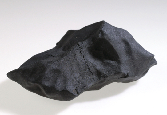 A large, smooth surfaced black rock. 