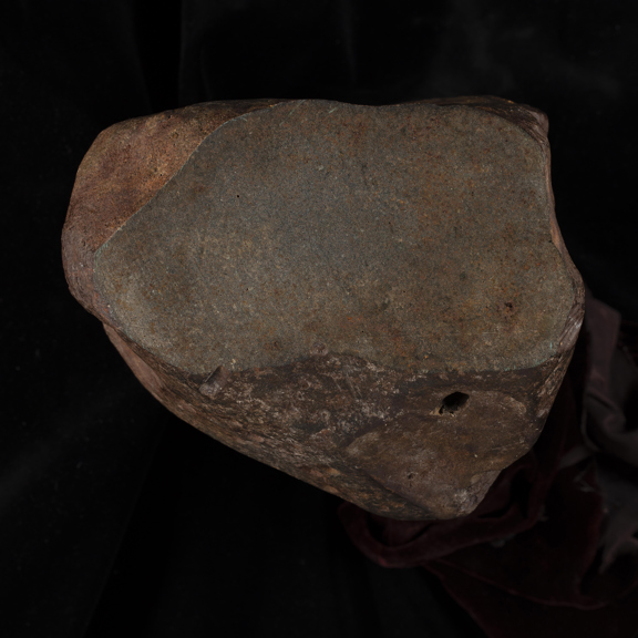 A reddish rock with a hole in it. 