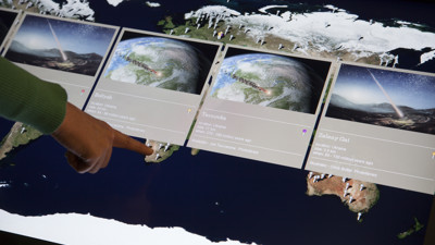 Visitor point at interactive display in Earth exhibition 