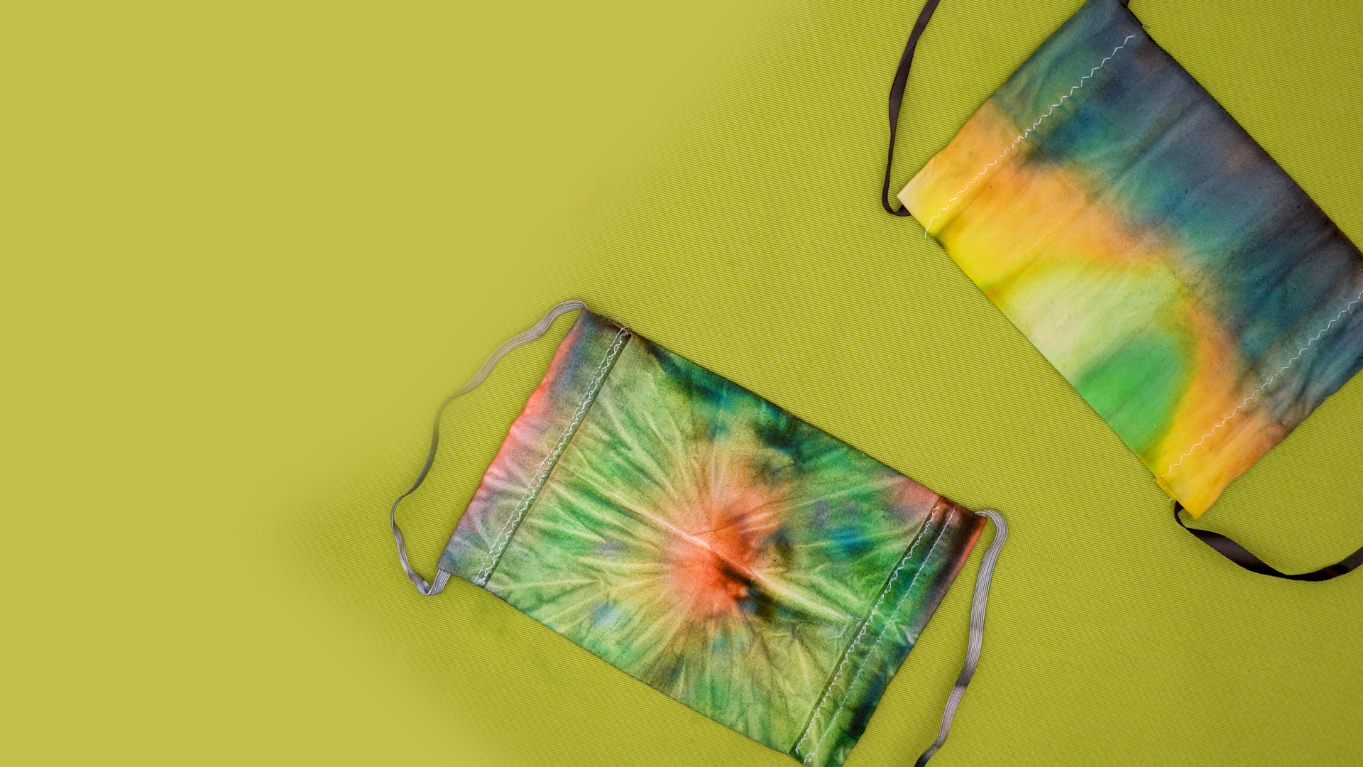 Tie-dyed masks on a green background