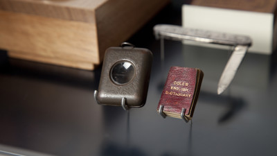 Miniature Cole's English Dictionary with its magnifying case and mini knife on display