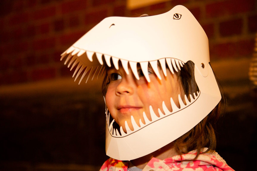 Child wearing a T-Rex mask made of card