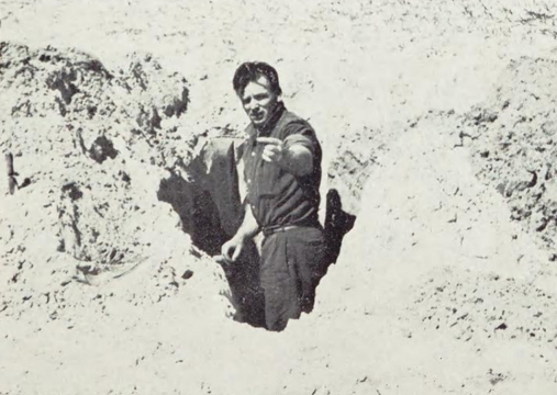 Person in a hole, holding fulgurite fragment