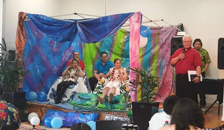 Four people on a stage draped with colourful cloth