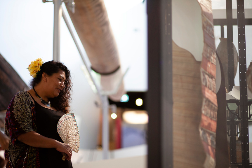Woman holding a fan, she is viewing an exhibition