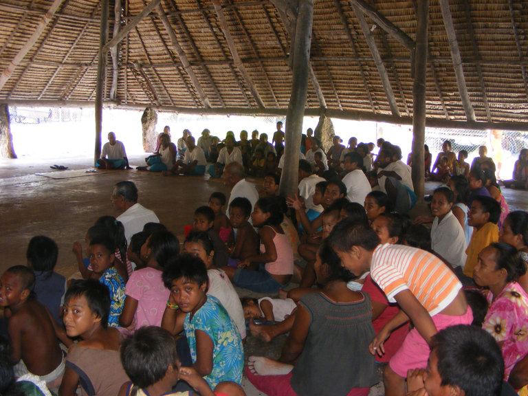 People sitting under the maneaba