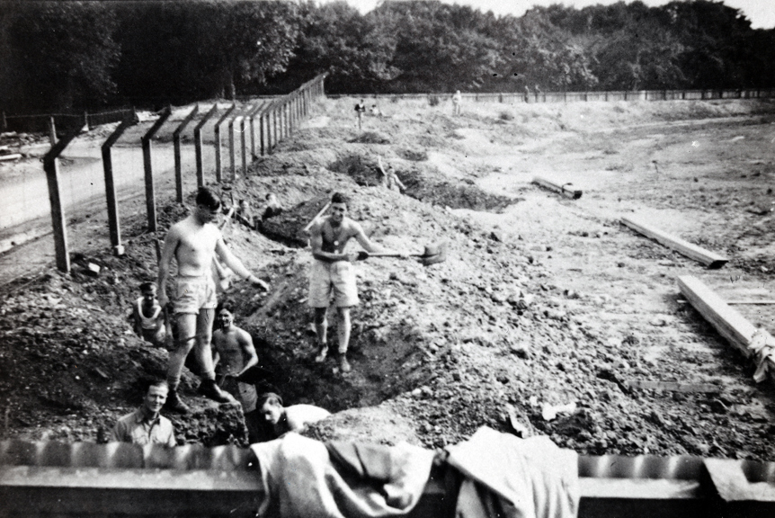 A black and white photo of trench diggers outside Melbourne's Exhibition Buildigs