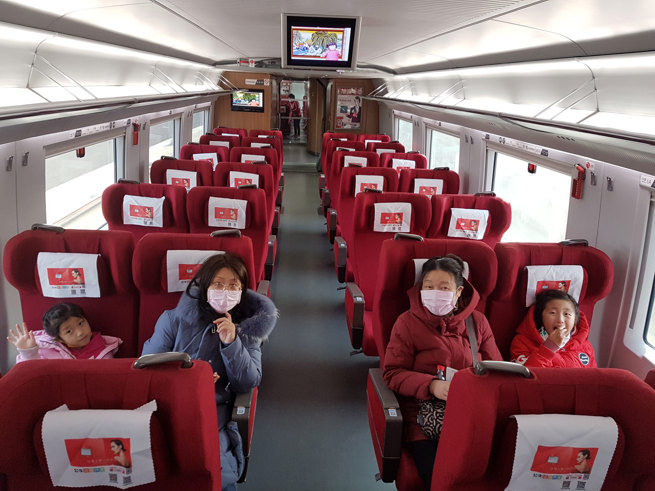 Four people sitting in a train. There is no one else in the carriage