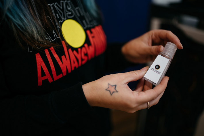 Detail of hands holding a small bottle hand sanitiser