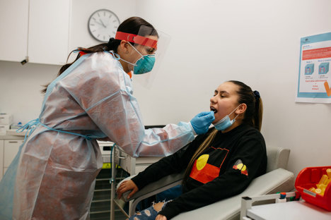 Woman preform a covid test on a female patient