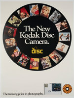 White poster with a black circle featuring photos. Text "The new Kodak disc camera. Turning point in photography" The camera is featured at the bottom of the poster.