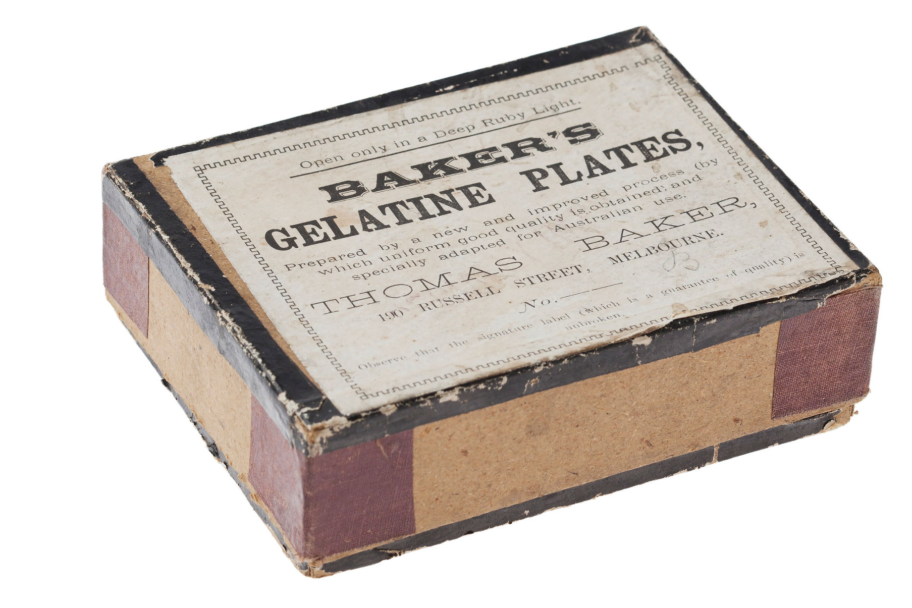 Small cardboard box with a lid. There is a label on the lid