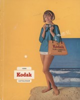 Cover of a catalogue. It has a yellow background with a cut out image of a woman standing on the beach holding a camera and a Kodak bage. 