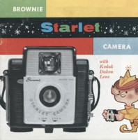 The cover of a paper brochure printed in full colour with a small cartoon 'Brownie' creature (like an elf) on the cover, next to a large image of the camera.