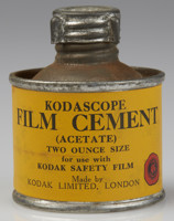 Small round tin bottle with a yellow label with black text