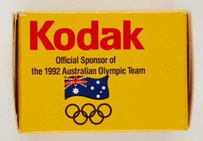 Side of a small yellow box. There text saying "Kodak: Official Sponsor of the 1992 Australian Olympic Team" The Olympic rings and Australian flag are also printed on it.