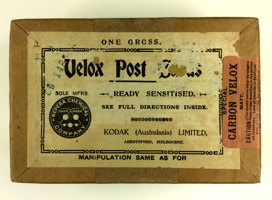 Brown thick cardboard box, with a white label and orange sticker