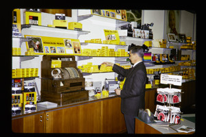 Man inside a Kodak retail shop picking a product off the shelf