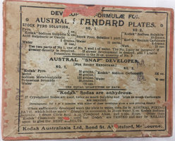 Red box with a white paper label. The label is printed in black text and is torn on the edges.