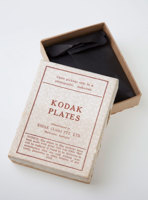 Empty box with the lid ajar reveal the inside. The lid is white with red print.