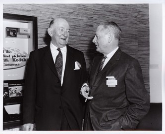 Two men standing and looking at each other speaking