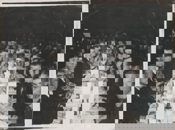 Group of men and woman sitting at long function table