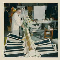 Man in a white lab coat using a machine