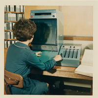 Woman sitting at a desk using a blue viewing machine