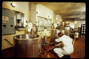 Person in white overalls operating industrial machinery