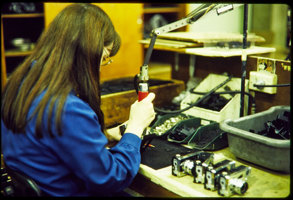 woman wear a blue uniform using tools to make a camera