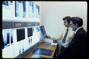 Two men looking at x-rays on a lightbox